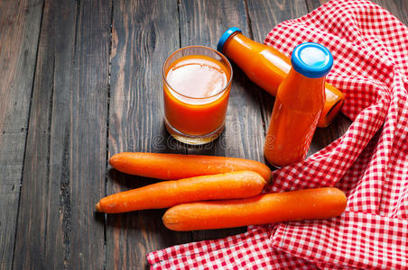 胡萝卜汁在玻璃和蔬菜旁边
