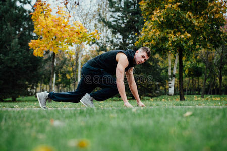 健身男子训练和慢跑在秋季公园。 准备开始了。 健康的生活方式