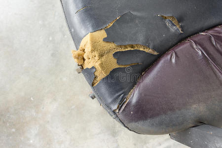 黑色办公椅旧损坏皮革和脏,时间更换照片