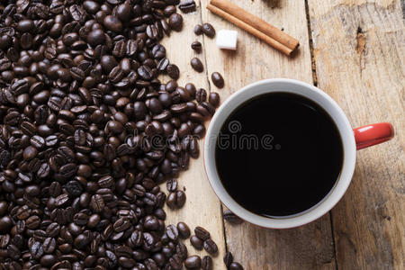 木制背景上的咖啡杯和咖啡豆。