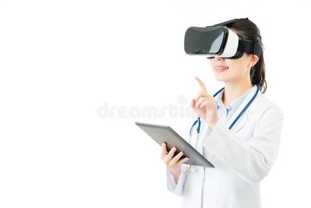 亚洲医生使用数字平板控制VR耳机屏幕