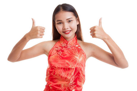 穿中国旗袍的亚洲女孩竖起大拇指.照片