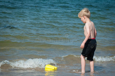 男孩在海里玩黄色的布基
