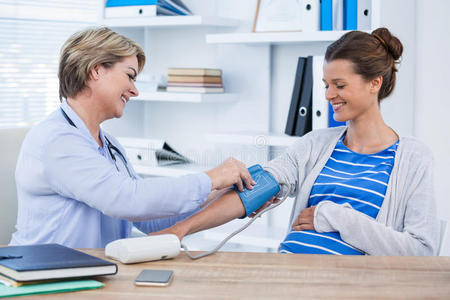 女性医生检查病人的血压