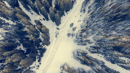 空中俯瞰积雪覆盖的道路穿过森林。