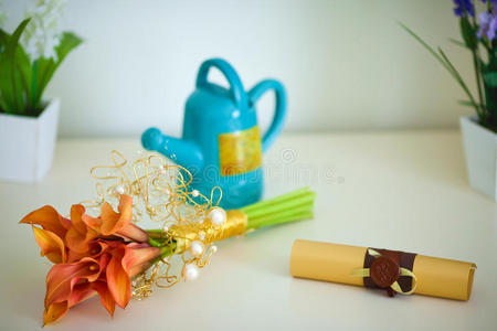 一束马蹄莲，茶壶和卷在桌子上。 家居装饰