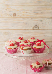 蛋糕上有白色的糖霜，装饰着粉红色的糖果和丝带。