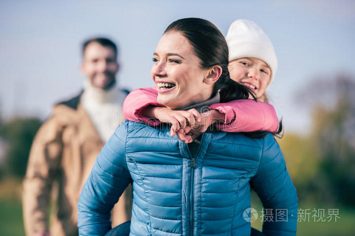 快乐的母亲背着小女儿