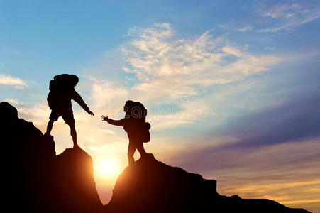 援手登山者通过互相帮助来向他的同伴伸出援手照片