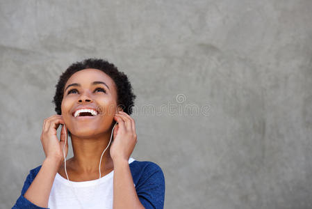 迷人的年轻黑人女人带着耳机微笑