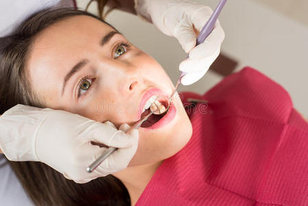 牙医在牙医办公室检查一名女性病人牙齿