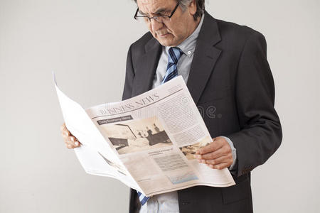 商人在灰色背景下阅读报纸