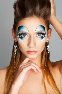 一个年轻女孩用明亮的蓝色化妆的美丽肖像。 艺术美设计。