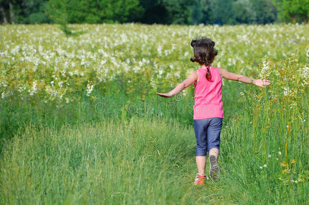 草地上开心的小孩孩子在绿色的春天草地上,孩子们跑步,玩得开心照片
