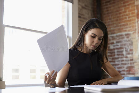 女商人在办公室的文件上做笔记