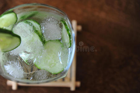 新鲜黄瓜夏季饮料在一个玻璃与冰在木桌上。 文本的自由空间
