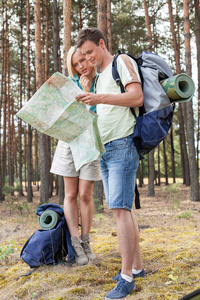 青年徒步旅行夫妇在森林中阅读地图
