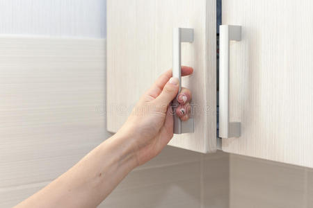 女手打开柜门,关上.照片