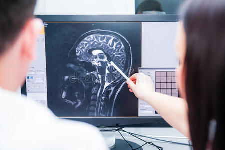医生考虑和讨论大脑的磁共振图像MRI。 背面，选择性聚焦