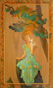 一个闻着花的漂亮女孩的肖像. 木头上的油画.照片