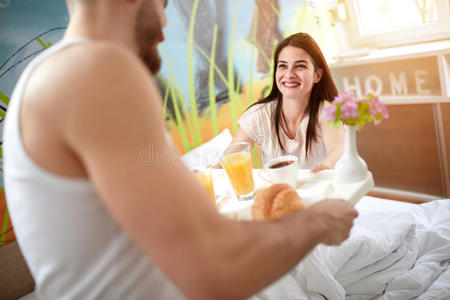 女孩从男朋友那里拿托盘和早餐