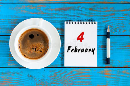 2月4日。 每月4日，在工作场所背景下，在日历和早晨咖啡杯上查看顶部。 冬天的时候