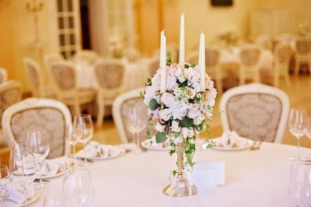 客人桌子与烛台在丰富装饰的婚宴客房