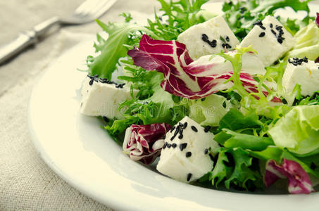 绿色沙拉，菠菜，羊肚菌，花生米，费塔奶酪和黑芝麻在蓝色的木制背景