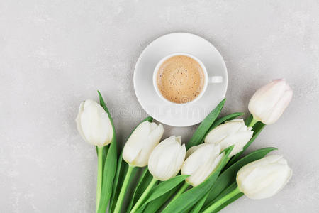 咖啡杯与春天的花朵,早上好,在灰色的石头桌面上,平躺风格.