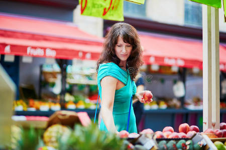 法国女人在市场上选择水果