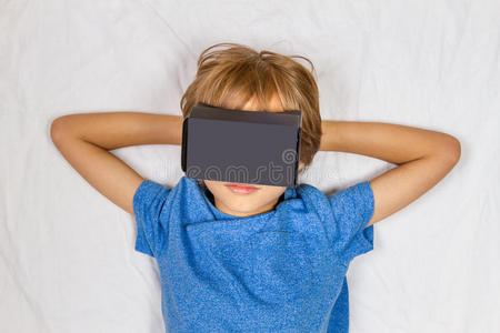 孩子躺在床上用3D虚拟现实，VR纸板眼镜