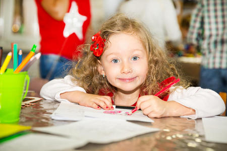 可爱的女婴在托儿所用彩色铅笔画画。 蒙台梭利学前班幼儿园的孩子。