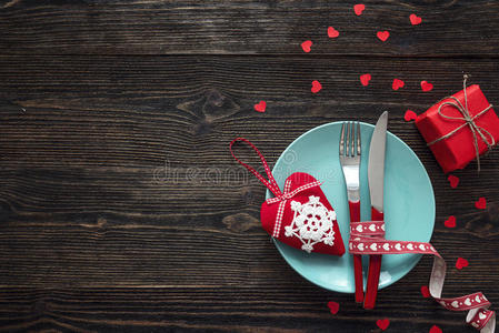 节日的桌子设置与叉子，刀和心在黑暗的木头上