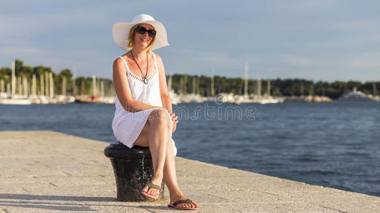 一个在海滩上戴着夏帽的漂亮女人。