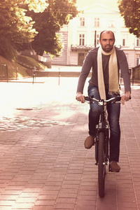 日落时分，在城市里骑自行车的时髦男人关门。