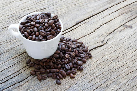 木制背景上的杯咖啡和咖啡豆