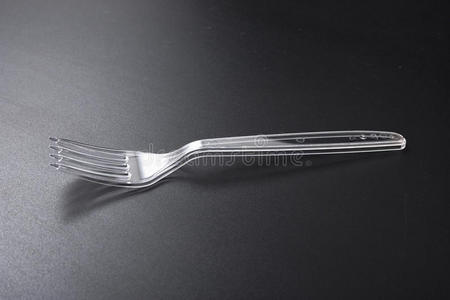一次性塑料餐具。 黑色背景上的叉子和刀。