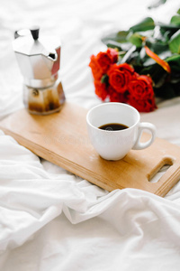 一杯咖啡，木板上的咖啡，白色背景上的一束红玫瑰