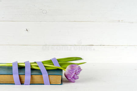 礼物，紫色郁金香和书在木桌上