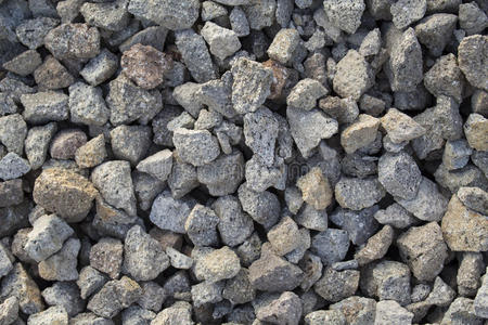 灰色砾石特写照片为背景。 用于施工的桩中锋利的灰色石头。
