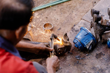 亚洲人工匠正在一家工厂使用气焊钢