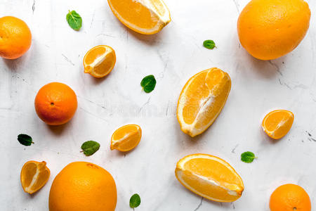 新鲜橙色水果与薄荷在桌子背景顶部视图模式