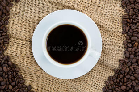 咖啡杯与咖啡豆安排在麻袋上