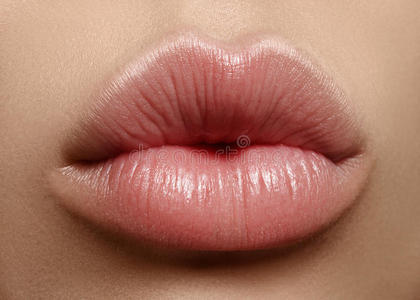 特写吻自然唇妆。 美丽丰满的嘴唇在女性的脸上。 清洁皮肤，新鲜化妆。 水疗温柔的嘴唇