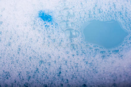 蓝色的水覆盖着泡沫和洗发水的气泡