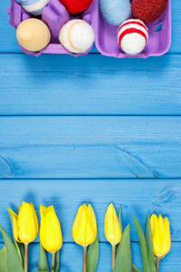 一束新鲜郁金香和复活节彩蛋包裹毛线，复活节装饰，文案空间为文字