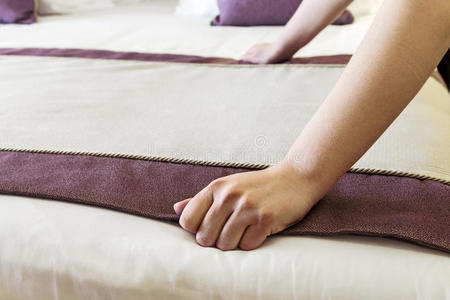 女性的手纠正了床上的毯子