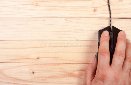 黑色电脑鼠标与一只手在一个轻木背景与复制空间为您的文本。 上面的风景