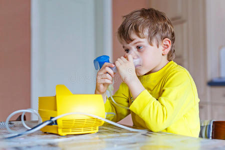 可爱的小男孩用吸入器的面具做吸入治疗