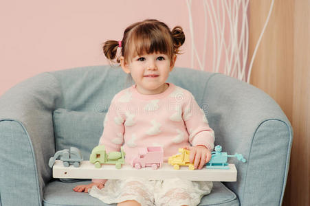 可爱快乐的2岁女婴在家里玩木制玩具